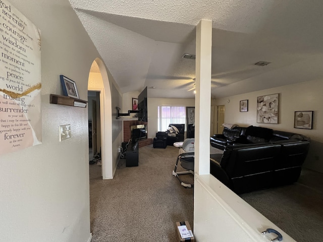 misc room with carpet, visible vents, ceiling fan, vaulted ceiling, and a textured ceiling