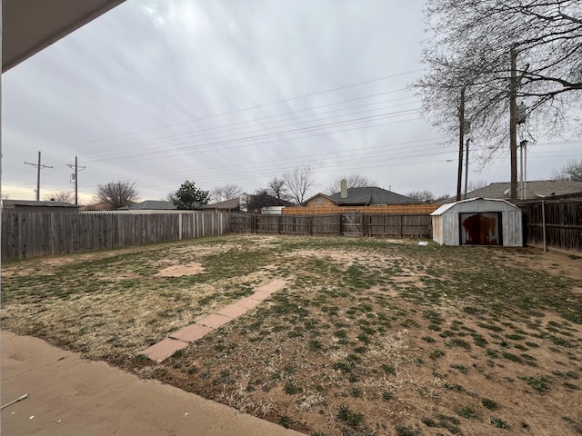 view of yard with an outdoor structure, a storage unit, and a fenced backyard