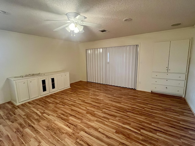 5013 57th St, Lubbock, TX 79414 - unfurnished bedroom with light wood-style flooring, a textured ceiling, and a ceiling fan