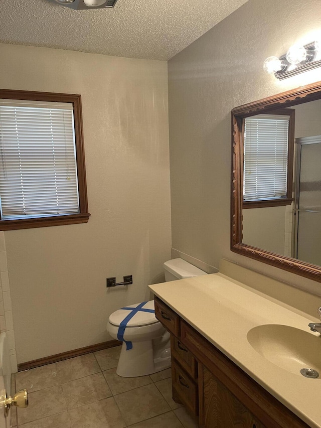 5013 57th St, Lubbock, TX 79414 - bathroom with a shower with door, vanity, a textured ceiling, tile patterned floors, and a bathtub