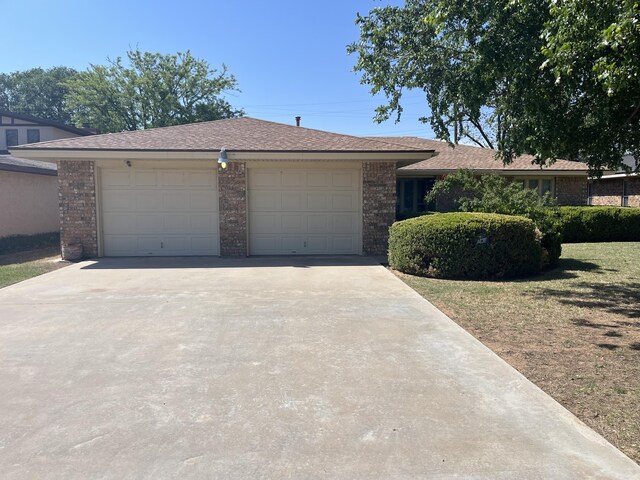 5013 57th St, Lubbock, TX 79414 - view of front of property featuring concrete driveway, brick siding, and a garage