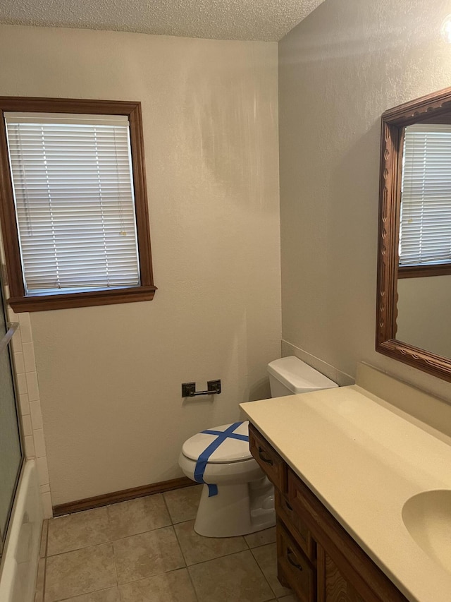 5013 57th St, Lubbock, TX 79414 - full bathroom featuring vanity, tile patterned floors, a textured ceiling, and shower / bath combination with glass door