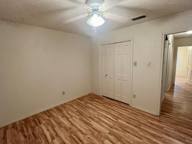 5013 57th St, Lubbock, TX 79414 - unfurnished bedroom featuring light wood-type flooring, a textured ceiling, a closet, and ceiling fan