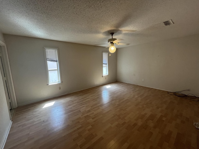 5013 57th St, Lubbock, TX 79414 - empty room with plenty of natural light, wood finished floors, a ceiling fan, and a textured ceiling