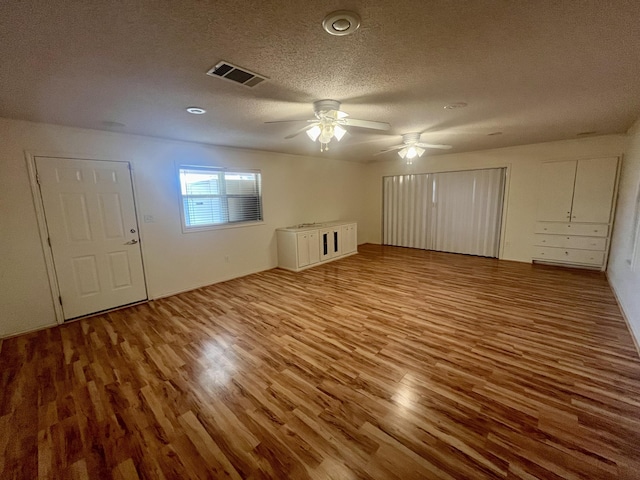 5013 57th St, Lubbock, TX 79414 - unfurnished living room featuring wood finished floors, a textured ceiling, and a ceiling fan