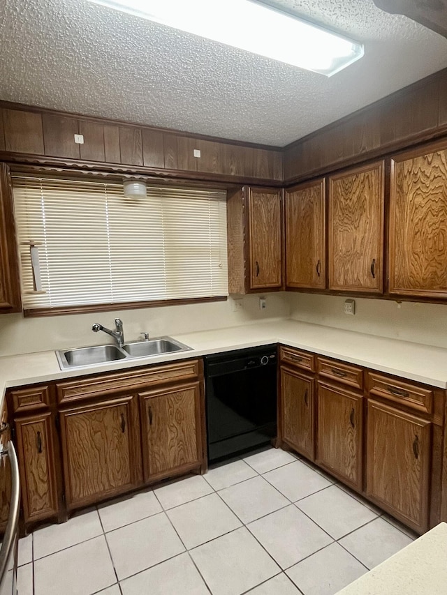 5013 57th St, Lubbock, TX 79414 - kitchen with black dishwasher, a textured ceiling, light tile patterned flooring, light countertops, and brown cabinetry