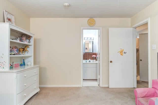 carpeted bedroom featuring ensuite bathroom and sink