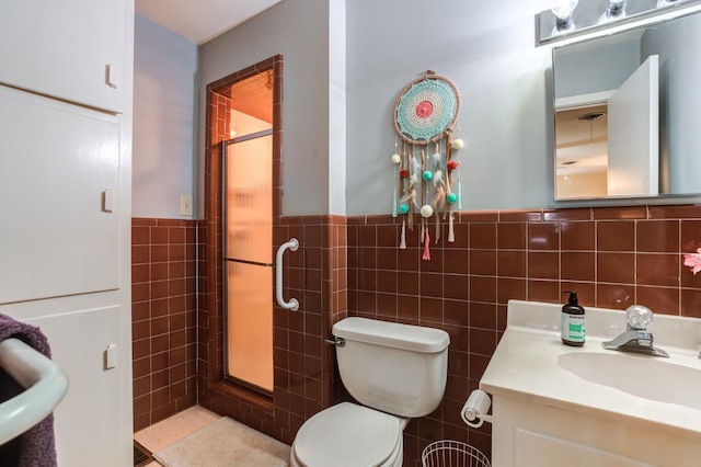 bathroom with tile walls, vanity, and toilet