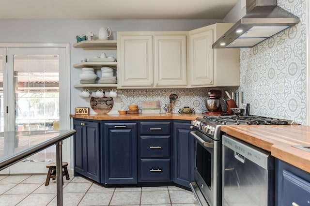 kitchen with butcher block counters, stainless steel appliances, range hood, and blue cabinetry