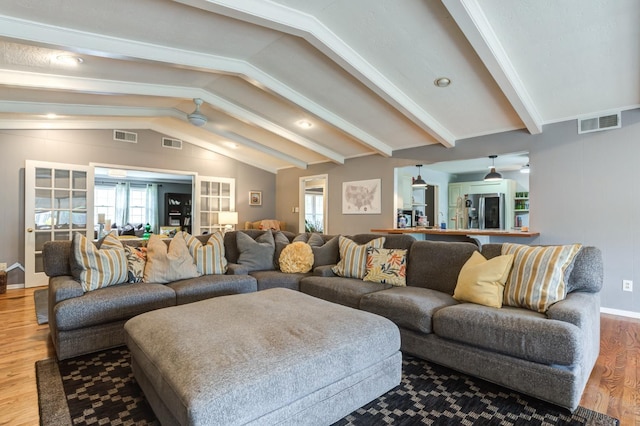 living room with ceiling fan, wood-type flooring, lofted ceiling with beams, and a healthy amount of sunlight