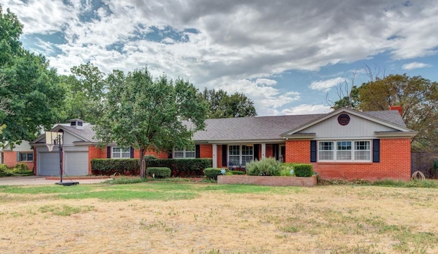 single story home featuring a garage, driveway, brick siding, and a front yard