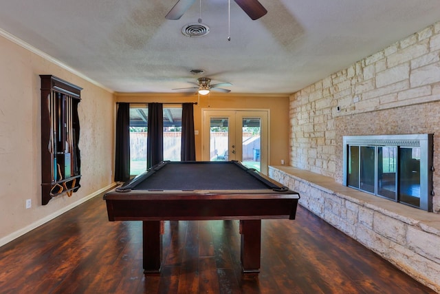 rec room featuring french doors, a textured ceiling, ornamental molding, dark hardwood / wood-style floors, and a fireplace