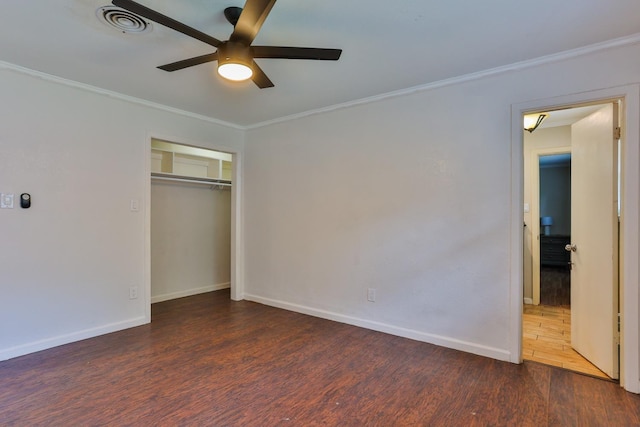 unfurnished bedroom featuring dark wood-type flooring, ceiling fan, ornamental molding, and a closet