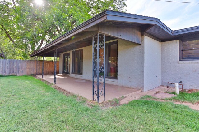 back of property featuring a lawn and a patio