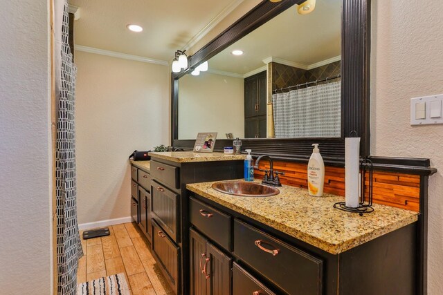 bathroom featuring ornamental molding, wood-type flooring, and vanity