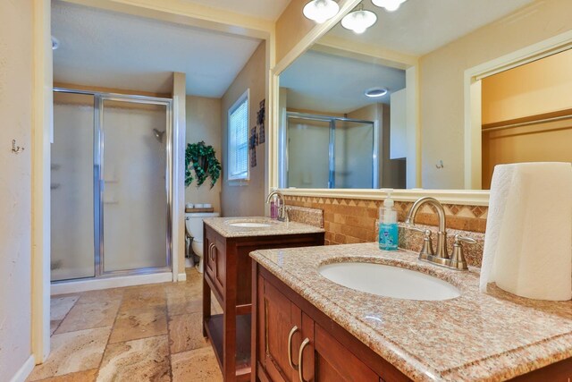 bathroom with tasteful backsplash, vanity, and a shower with door