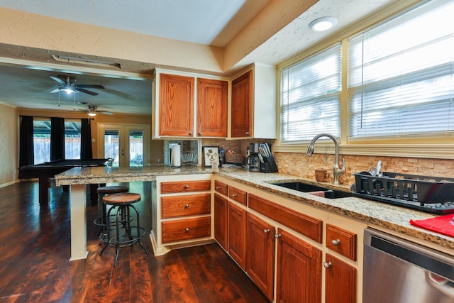 kitchen with french doors, dark wood-type flooring, sink, stainless steel dishwasher, and kitchen peninsula