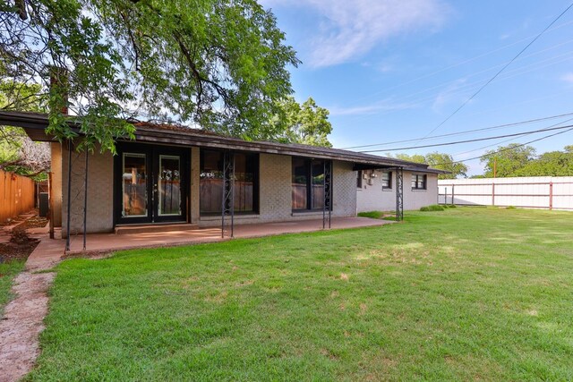 back of house with a yard and a patio area