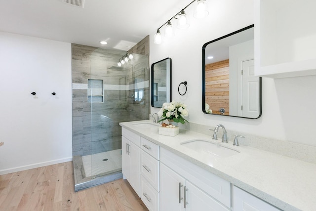 bathroom with wood-type flooring, vanity, and a shower with shower door