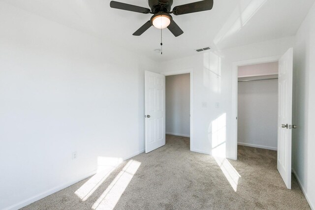 unfurnished bedroom with light colored carpet, ceiling fan, and a closet