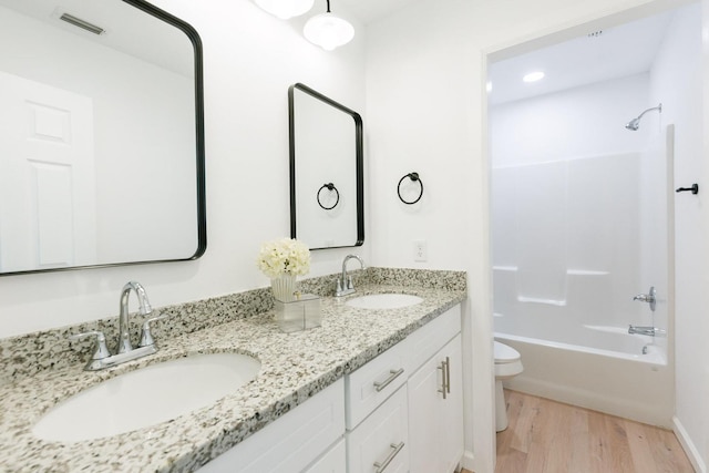 full bathroom with vanity, wood-type flooring, shower / bathtub combination, and toilet