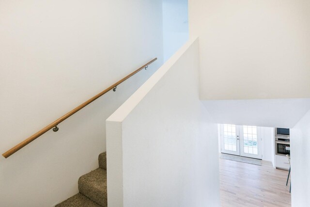 staircase featuring hardwood / wood-style floors and french doors