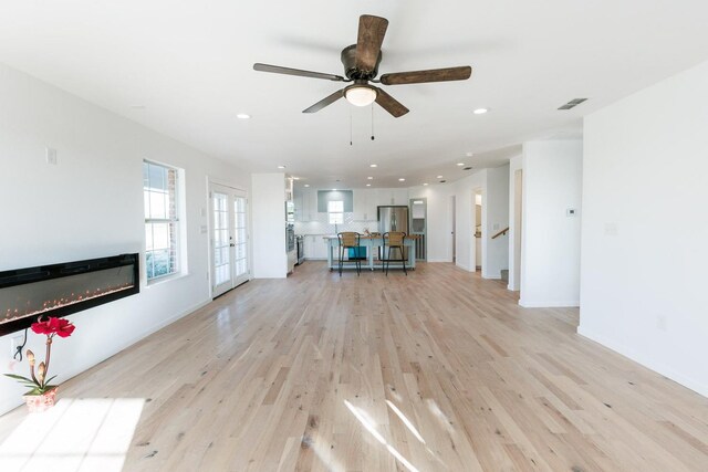 unfurnished living room featuring light hardwood / wood-style flooring and ceiling fan