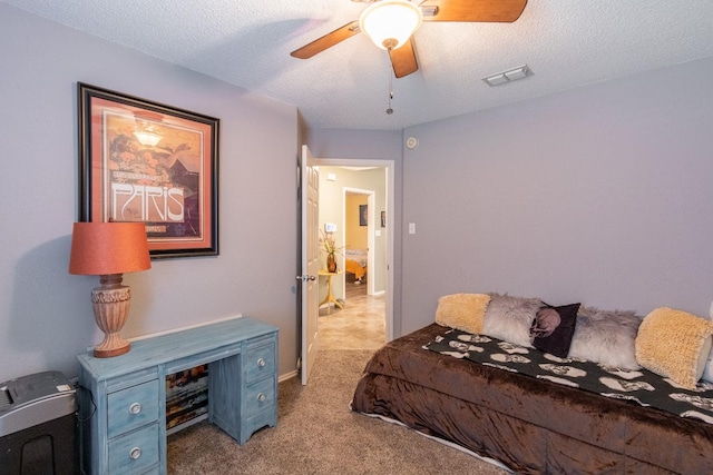 carpeted bedroom with ceiling fan and a textured ceiling