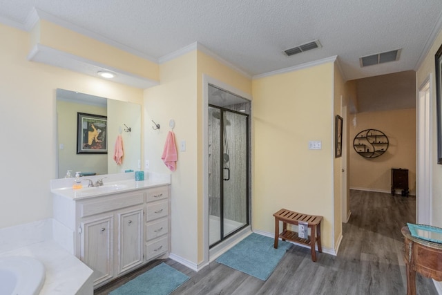 bathroom with hardwood / wood-style flooring, shower with separate bathtub, vanity, and a textured ceiling