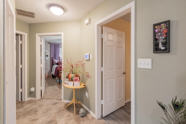 hallway with a textured ceiling