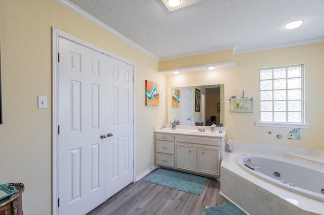 bathroom featuring hardwood / wood-style flooring, ornamental molding, vanity, and a textured ceiling