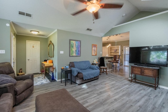 living room with ceiling fan, ornamental molding, vaulted ceiling, and light hardwood / wood-style flooring