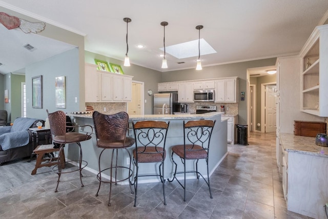 kitchen featuring a breakfast bar, white cabinetry, a skylight, hanging light fixtures, and appliances with stainless steel finishes