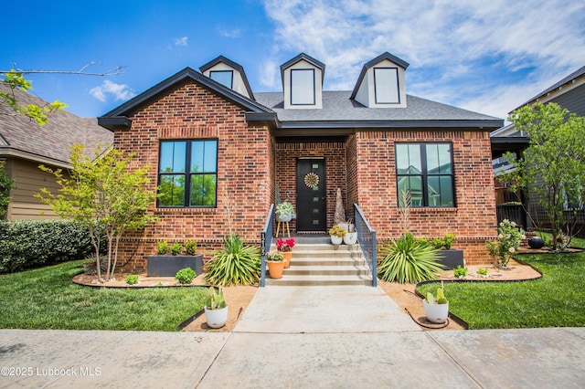 12105 Topeka Ave, Lubbock, TX 79424 - view of front facade featuring brick siding, a front yard, and a shingled roof