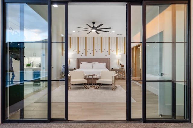 bedroom featuring a wall of windows, wine cooler, and wood finished floors