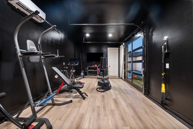 exercise room with a garage and wood finished floors