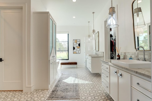 bathroom with vanity, backsplash, and a tub to relax in