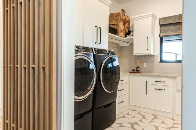 laundry area featuring separate washer and dryer and cabinets