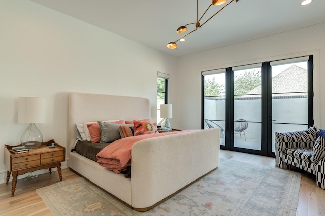 bedroom featuring wood-type flooring and access to exterior