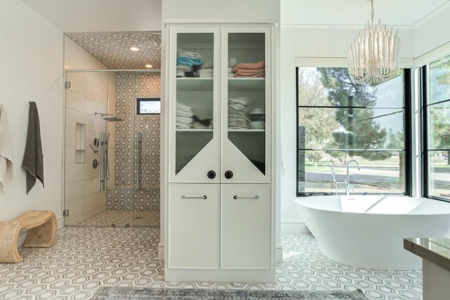 bathroom with shower with separate bathtub, tile patterned floors, and an inviting chandelier