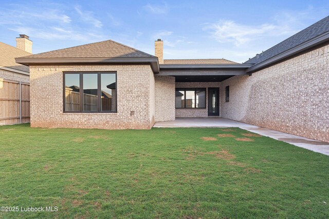 4806 139th St, Lubbock, TX 79424 - back of house featuring a patio area, brick siding, a chimney, and roof with shingles