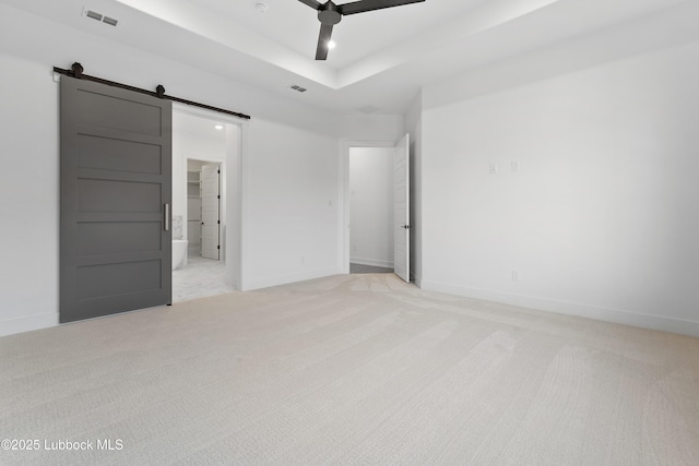 4806 139th St, Lubbock, TX 79424 - unfurnished bedroom featuring light carpet, a barn door, baseboards, a ceiling fan, and a tray ceiling