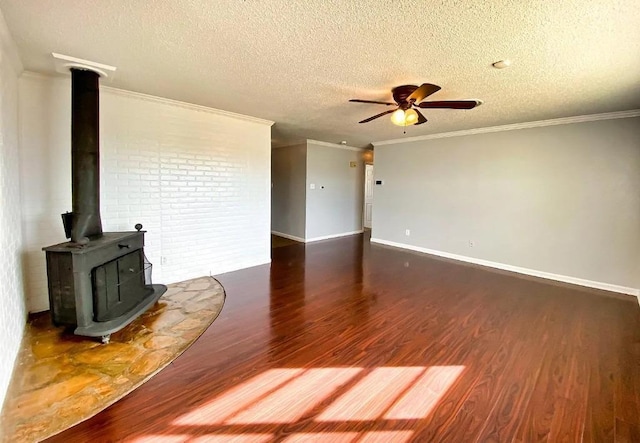 unfurnished living room featuring a textured ceiling, a wood stove, ornamental molding, dark hardwood / wood-style floors, and ceiling fan