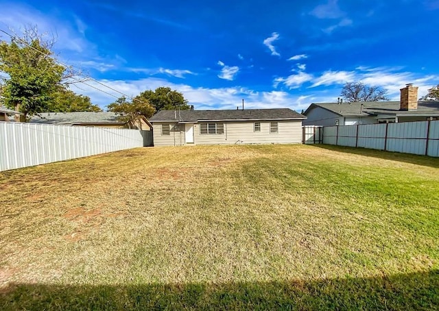 rear view of house featuring a yard