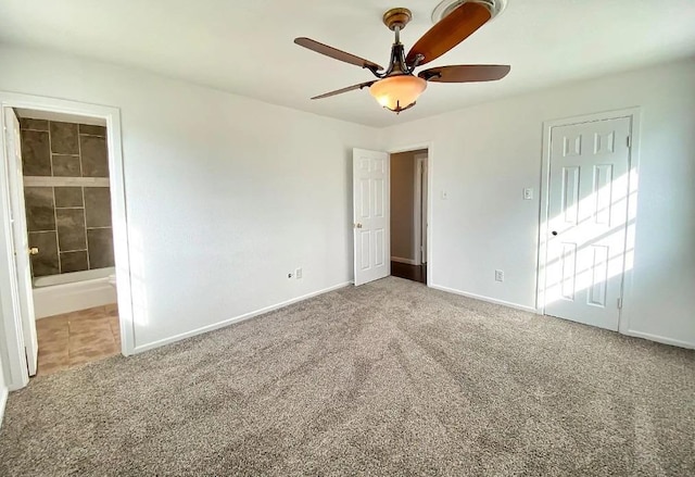 unfurnished bedroom with connected bathroom, carpet floors, and ceiling fan