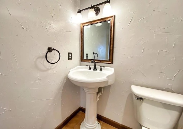 bathroom with toilet and tile patterned flooring