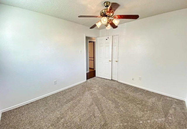 empty room with ceiling fan, carpet floors, and a textured ceiling