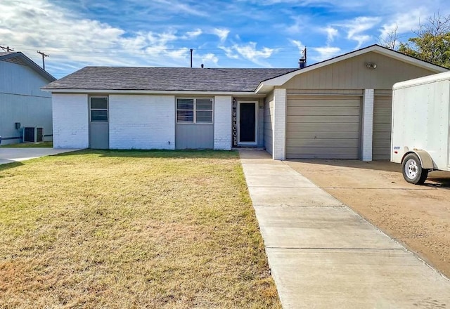 ranch-style home featuring a garage, central AC, and a front yard