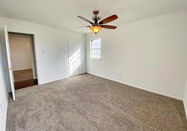 carpeted spare room featuring ceiling fan