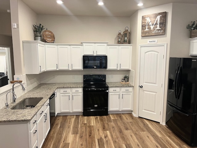 7022 34th Pl, Lubbock, TX 79407 - kitchen featuring black appliances, a sink, white cabinetry, light wood-type flooring, and recessed lighting
